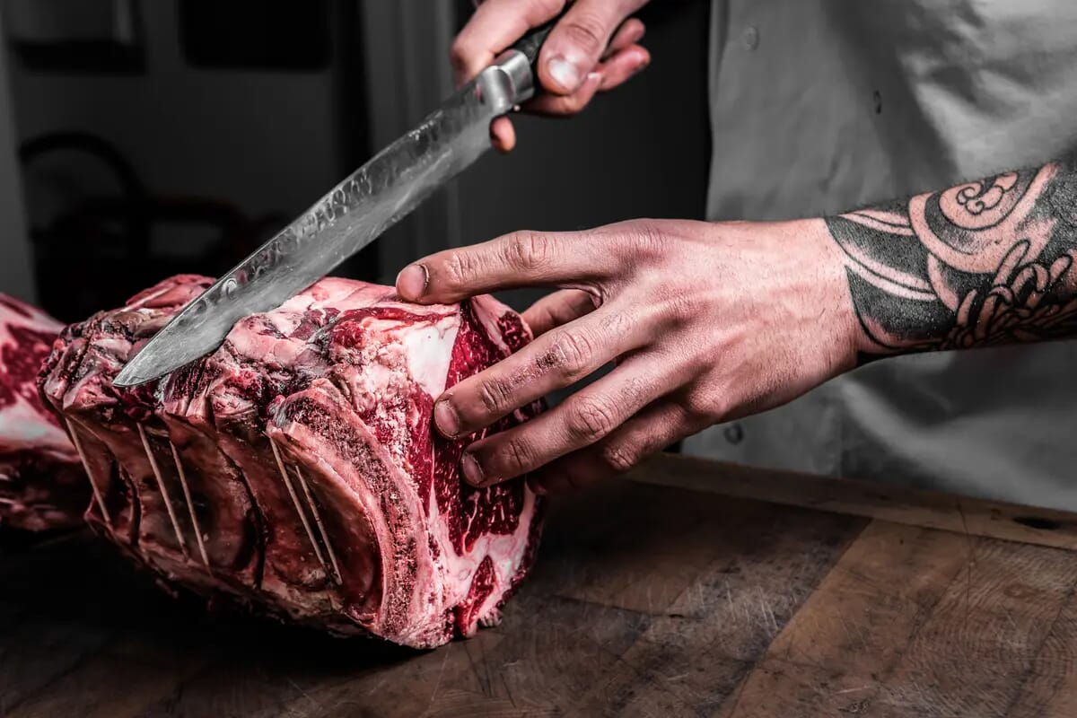 Chef cutting rib eye steaks food photography London